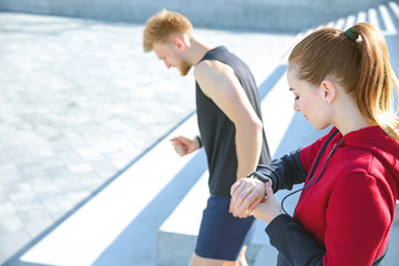 Sporty young woman checking her pulse outdoors