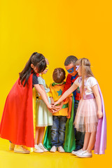 Fototapeta premium Cute little children dressed as superheroes on color background