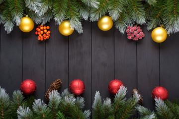 Christmas dark background with christmas decoration, christmas candy canes, christmas balls and fir branch. Top view with copy space