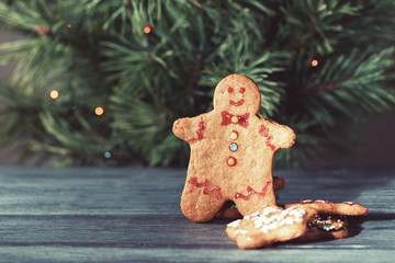 Traditional Christmas cookie in the shape of a man on a background of the Christmas tree