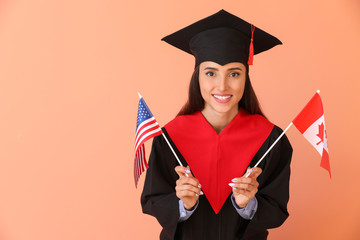 Female graduate with USA and Canadian flags on color background