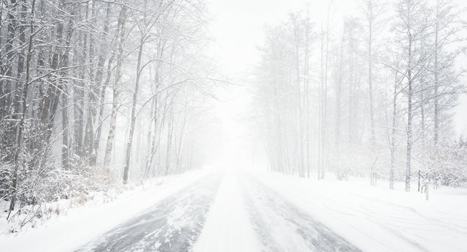 Snowy winter road during blizzard in Latvia
