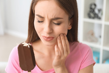 Young woman with sensitive teeth and cold ice-cream at home - obrazy, fototapety, plakaty