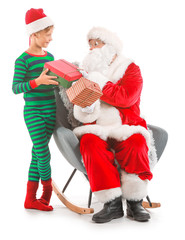 Santa Claus and little elf kid with gifts against white background