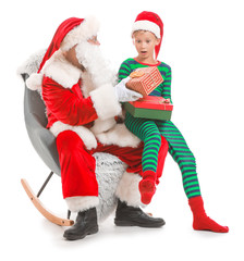 Santa Claus and little elf kid with gifts against white background
