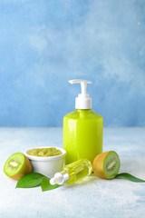 Cosmetics with kiwi on color background