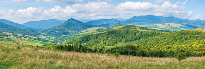 Fototapeta na wymiar panorama of a great countryside landscape. beautiful scenery in mountainous rural area. agricultural fields near forested hills, village in the valley and ridge with high peaks in the distance