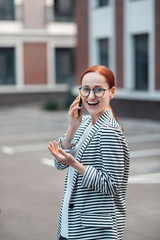 Cute red-haired young woman in a striped jacket