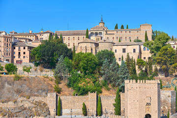 Colorful cityscape view of the Alcántara gate, the Conceptionists convent and Santa Cruz museum of the medieval walled city of Toledo, Castilla la Mancha, Spain. UNESCO world heritage site.