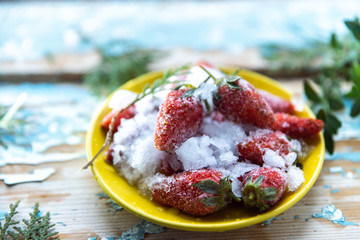 Frozen strawberries on a wooden blue background