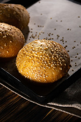 Homemade buns on burlap on wooden background