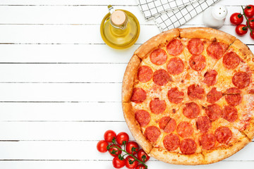 Fototapety  Pizza Pepperoni na białym tle drewnianych desek. Smaczna i pyszna pizza. Pizza z kiełbasą i serem