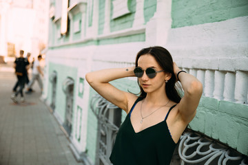 Fototapeta premium Sexy girl in a T-shirt and short shorts near the building