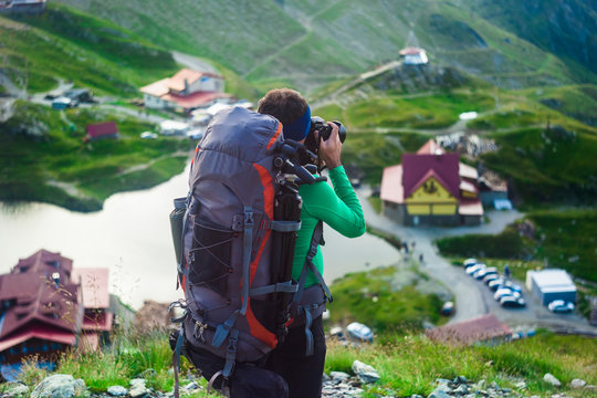 man with backpack on the mountain. photographer taking photos