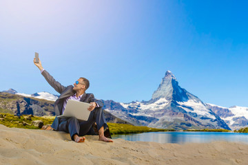 Fototapeta premium Man with laptop on the top of mountain