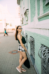 Sexy girl in a T-shirt and short shorts near the building