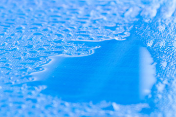 several rainwater drops on blue surface