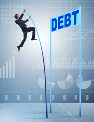 Businessman pole vaulting over debt in business concept