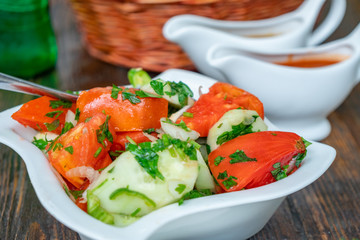 Tomato and cucumber salad with onion, pepper and parsly