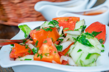 Tomato and cucumber salad with onion, pepper and parsly