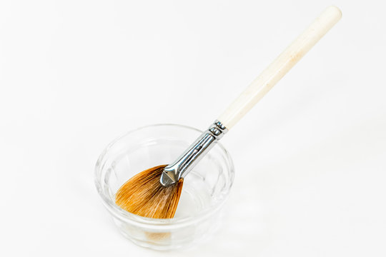 Chemical peel (face peel) liquid ingredient with cosmetic brush, for facial spa treatments by a cosmetologist. Often named a Jessner peel, using acid formulas for complexion and anti-aging treatments.