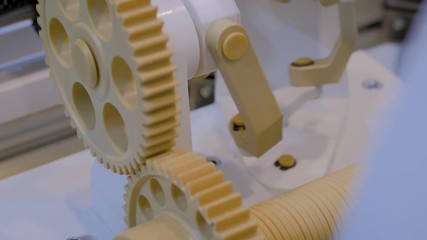 Automatic gear wheels system rotation with different speed - close up view. Machinery, mechanics, engineering, industry technology concept