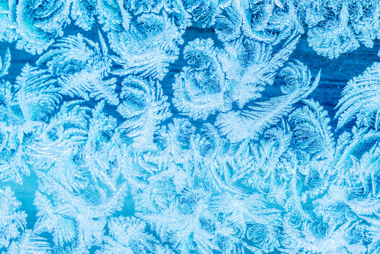 New Year and Christmas abstract icy frost cold weather snowy blue background with real ice crystals macro © Olga Akulinina