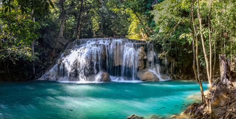 One of the largest waterfalls in Erawan National park in Thailand has a milky aqua pool with some fish