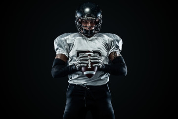 American football sportsman player in helmet on black background. Sport and motivation. Team sports.