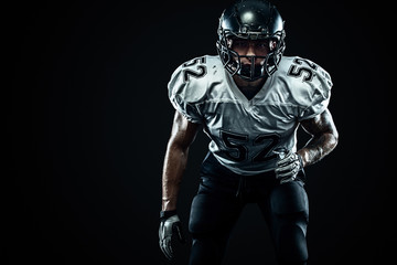 American football sportsman player in helmet on black background. Sport and motivation. Team sports.