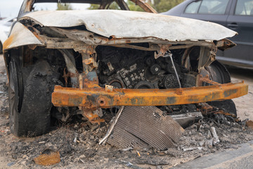 Fototapeta premium car after deliberate arson. destroyed vehicle after a fire melted is on the street.