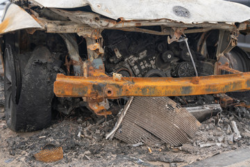 crushed melt car after deliberate arson. destroyed vehicle after a fire melted is on the street.