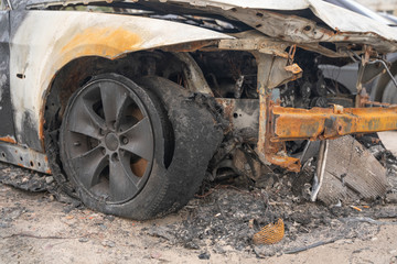 car after deliberate arson. destroyed vehicle after a fire melted is on the street.