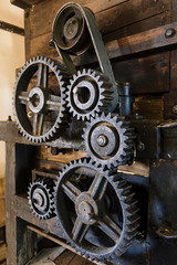 Fototapeta na wymiar Old mechanism. Old gears and pulleys with belt