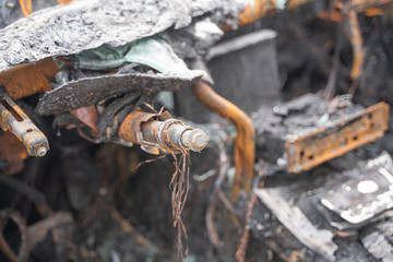 crushed melt car after deliberate arson. destroyed vehicle after a fire melted is on the street.