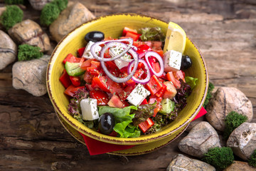 Nutritious, vitamin, healthy salad Greek from Fresh Tomatoes, Cucumbers, Olives, Peppers and Tofu.  Rustic Still Life