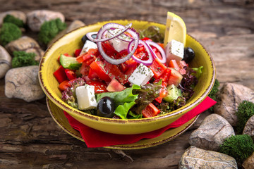 Nutritious, vitamin, healthy salad Greek from Fresh Tomatoes, Cucumbers, Olives, Peppers and Tofu.  Rustic Still Life