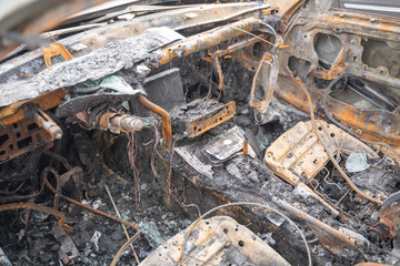 crushed melt car after deliberate arson. destroyed vehicle after a fire melted is on the street.