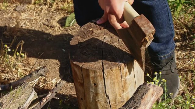 Boy work with wood-chopper ax on farm