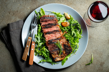 Grilled ribeye beef steak with red wine, herbs and spices. Top view. Flat lay