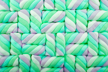 Top view on background texture of colorful twisted marshmallow candies. Copy space for your text.