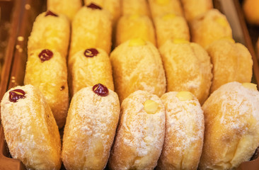 Close up row of sweet golden donuts with jam for breakfast