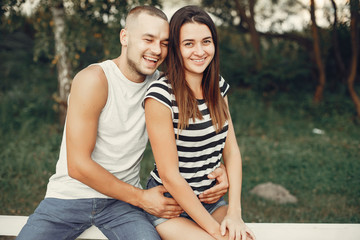 Naklejka premium Couple in a park. Woman in a t-shirt. Man with his wife