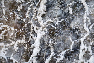 Fototapeta premium protrusions of white salts are on a black stone