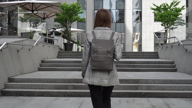 Girl Walking on the Stairs outside a modern building in slow motion. College, Student