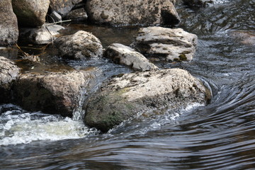 Naklejka na ściany i meble Water flowing over rocks