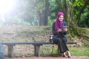 Muslim Businesswon on her table during a coffee break. Outdoor setting at a park.