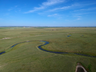 Rural environment with vast green field or valley, pathways, riv