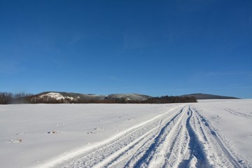 a road through the snow on the field