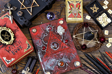 Still life with magical books, tarot cards and candles on witch altar table.